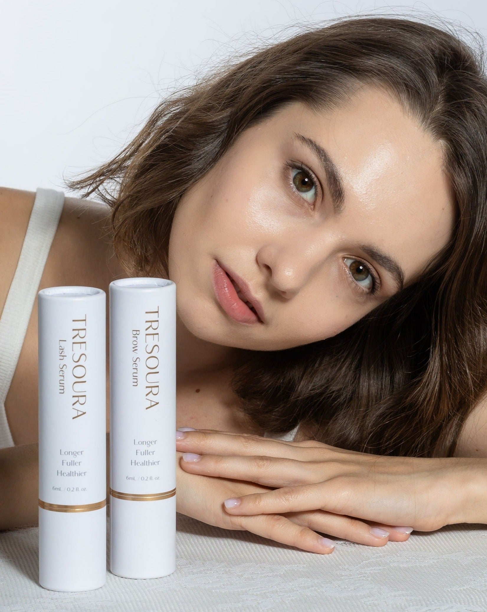 Model with Tresoura Lash & Brow Growth Kit, featuring both product boxes